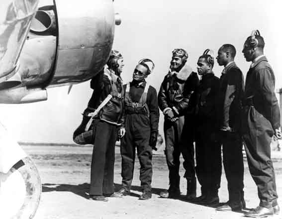 The first class of cadets, Spanky Roberts, Benjamin O. Davis, Ed Gleed, Mac Ross, and Lemuel Curtis with their instructor who is explaining the complexities of the AT-6 to them.